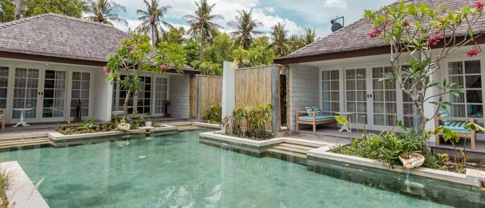 Serene resort bungalows with a refreshing swimming pool surrounded by palm trees on Gili Trawangan.