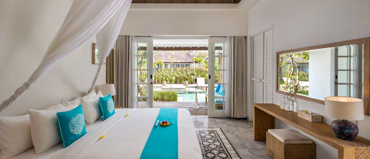 Elegant Gili Trawangan resort room featuring a canopy bed, vibrant turquoise accents, and a private pool.