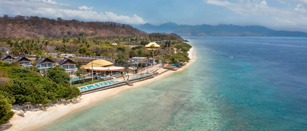 A tropical resort on Gili Trawangan with bungalows, a pool, sandy beach, and clear turquoise ocean.