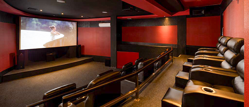 Luxurious in-house cinema with tiered leather recliners and a large screen at Kayon Jungle Resort, Ubud.