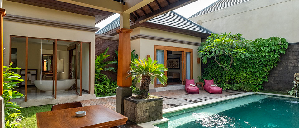 A serene private villa in Lovina, Bali, with a refreshing pool, pink lounge chairs, and tropical greenery.