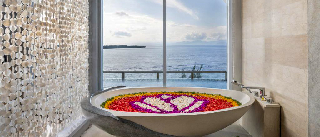 A luxurious bathtub with a flower petal design offers breathtaking ocean views at Nusa Penida.