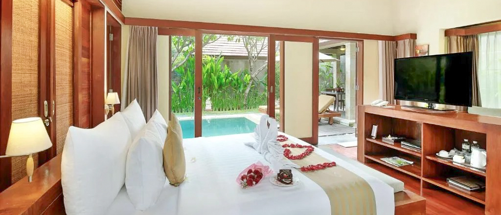 Luxurious bedroom in Seminyak with a king bed, romantic decorations, and a private pool view.