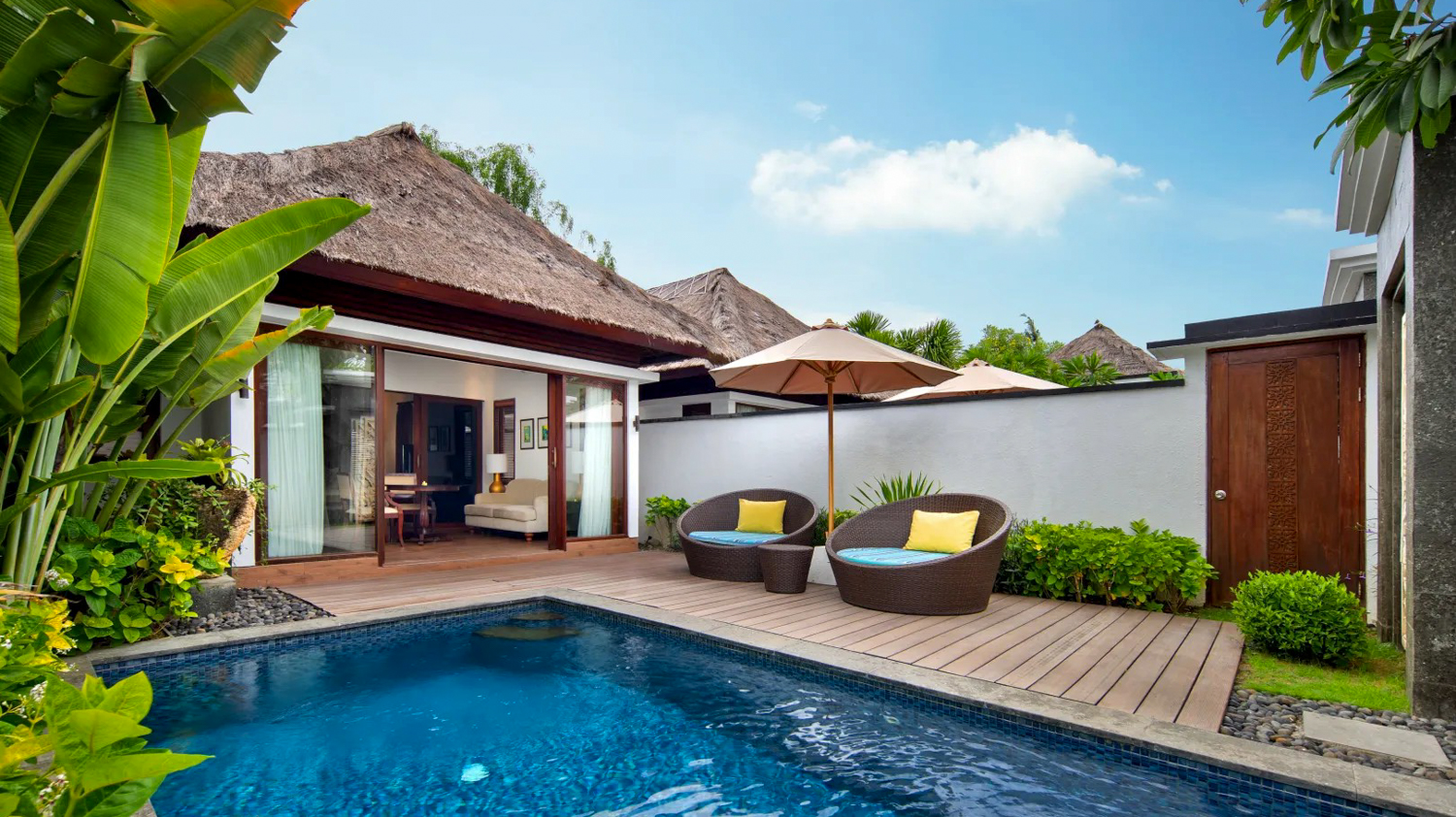 Inviting private villa in Bali with a sparkling pool, comfortable outdoor seating, and lush greenery.