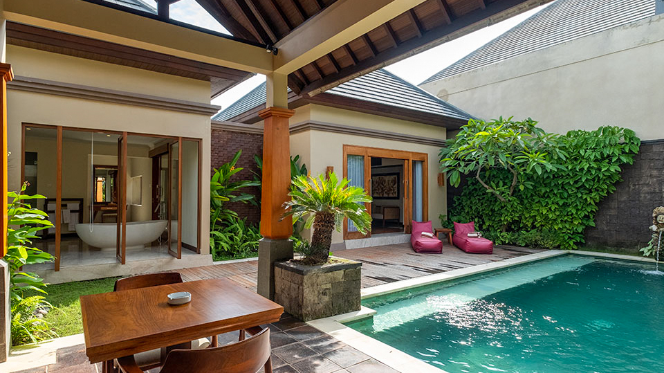 A luxurious private villa in Bali with a sparkling pool, outdoor dining, and lush tropical gardens.