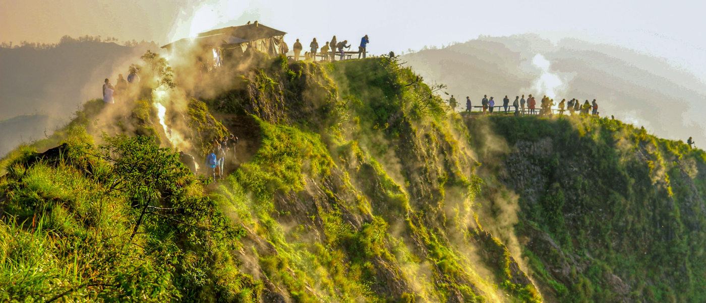 Hikers enjoy a beautiful sunrise walk along the misty green Campuhan Ridge in Ubud, Bali.