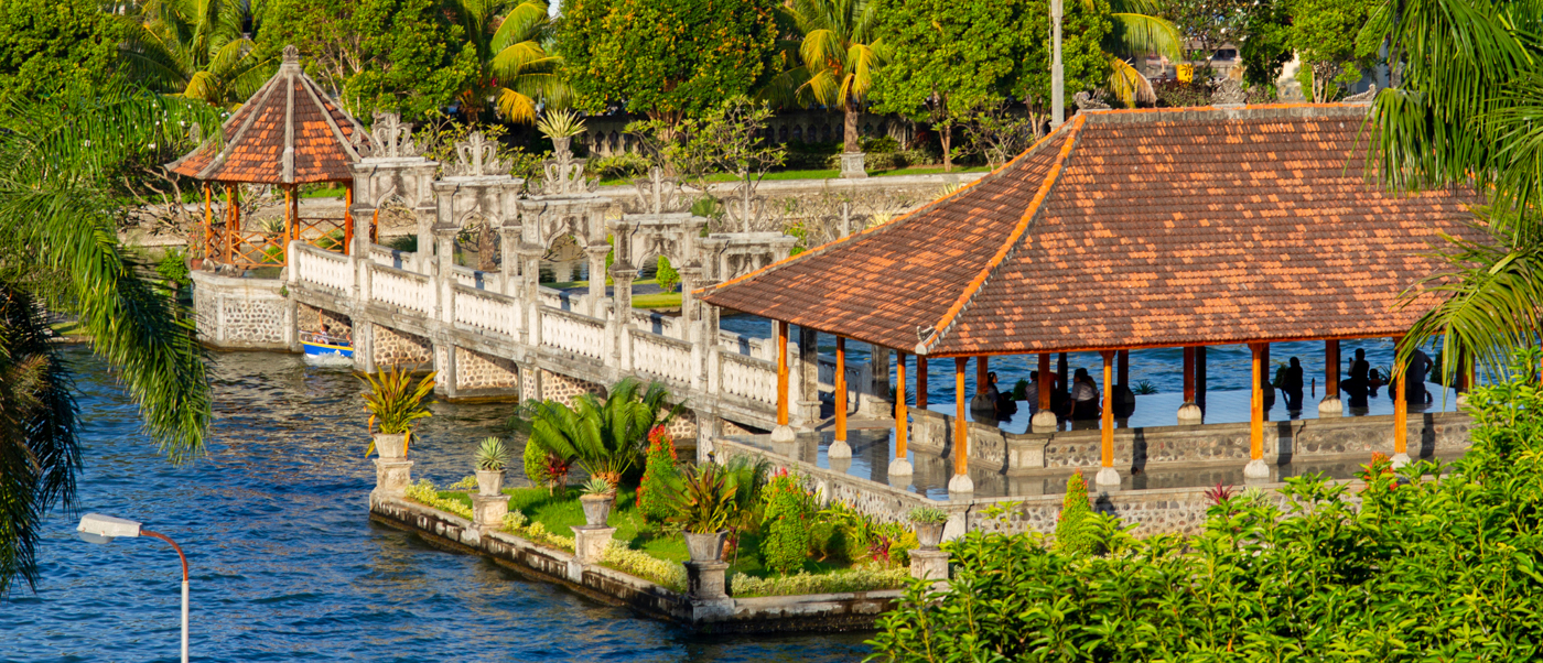 Taman Ujung Water Palace in Bali, featuring traditional buildings, ornate bridges, and serene tropical gardens.