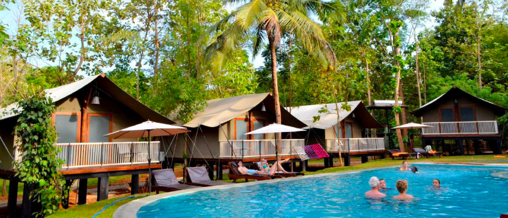 People swim and relax by a pool at a luxurious tented safari camp in Sri Lanka.