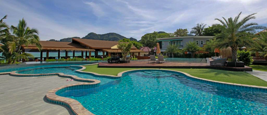 Beautiful resort on Phi Phi Islands with multiple pools, palm trees, and the Andaman Sea beyond.