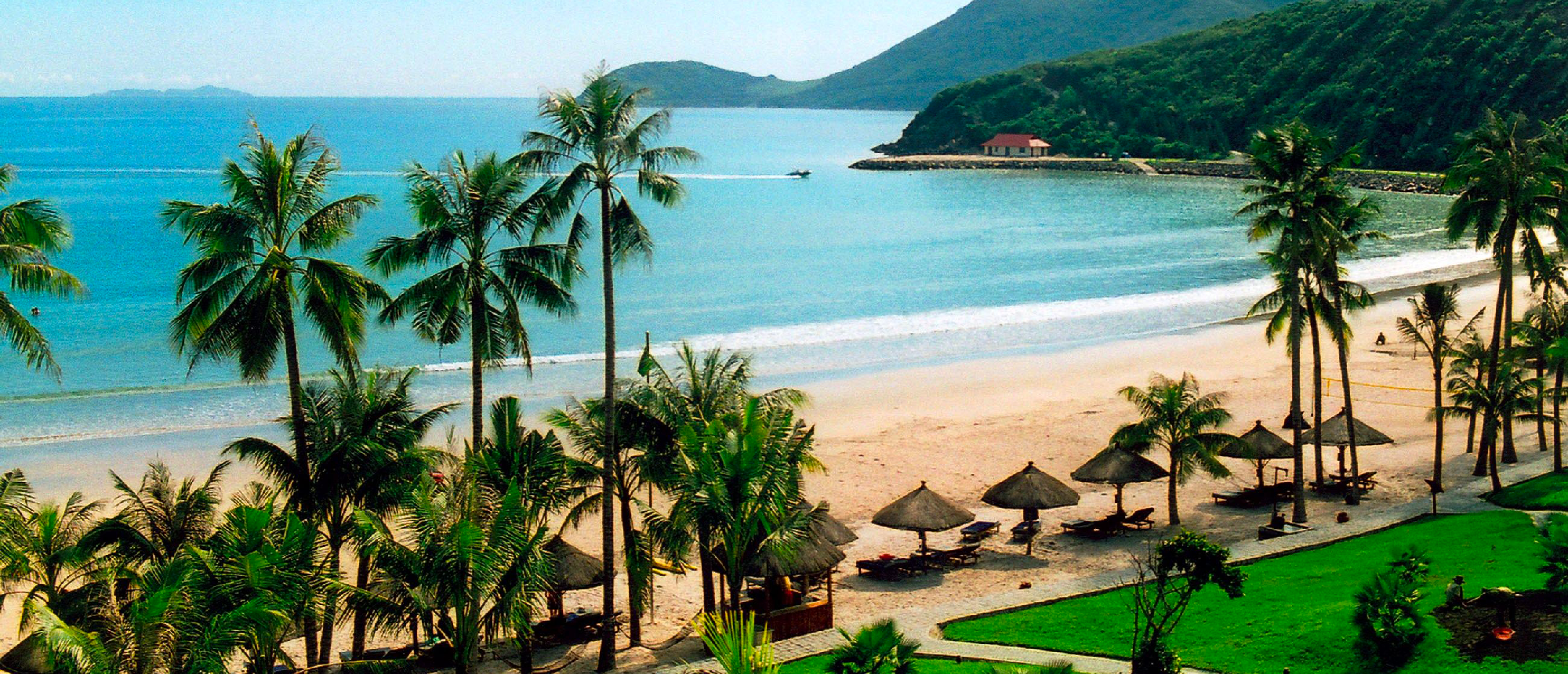 A serene tropical beach in Mui Ne with palm trees, thatched umbrellas, and calm blue water.