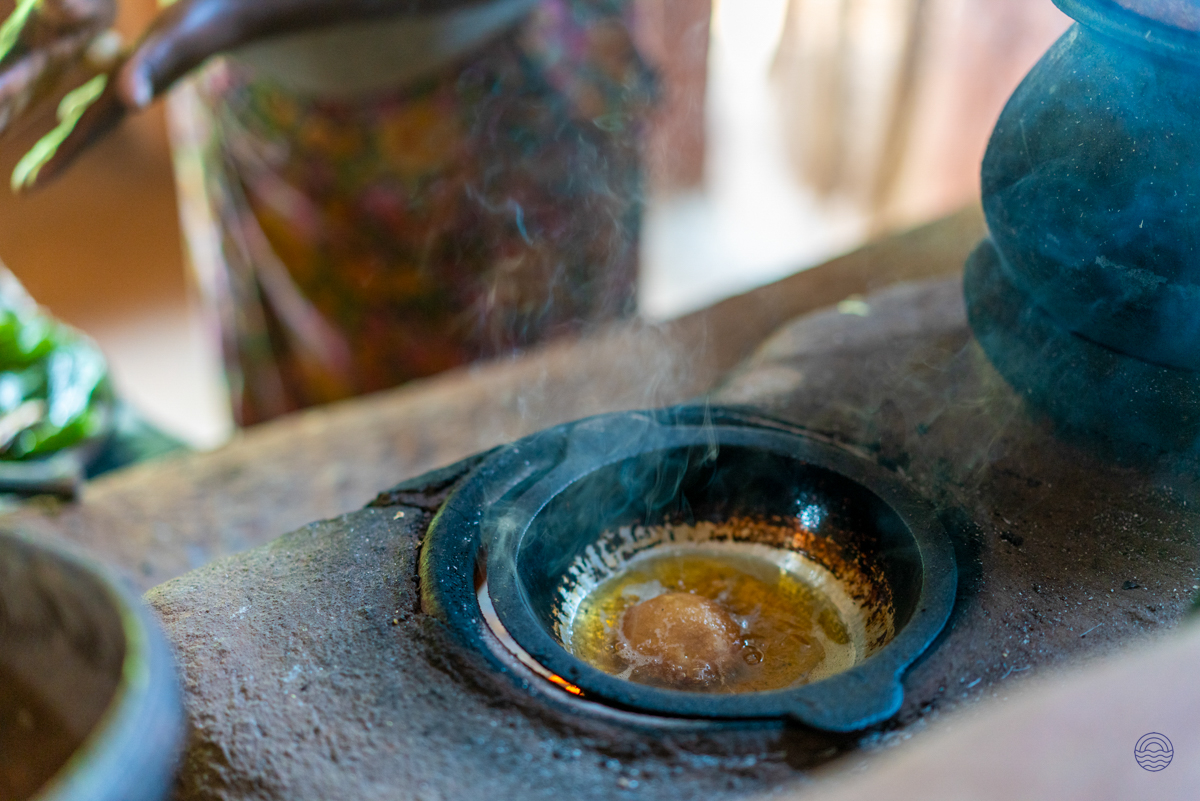 Traditional Sri Lankan cooking, with oil bubbling in a pot on a rustic stove in a Sigiriya village.