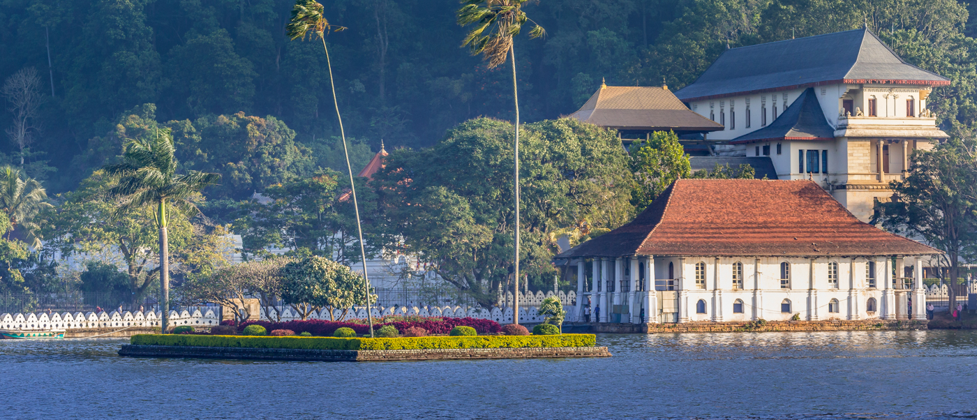 Kandy Lake with the majestic Temple of the Tooth Relic and surrounding lush green hills.