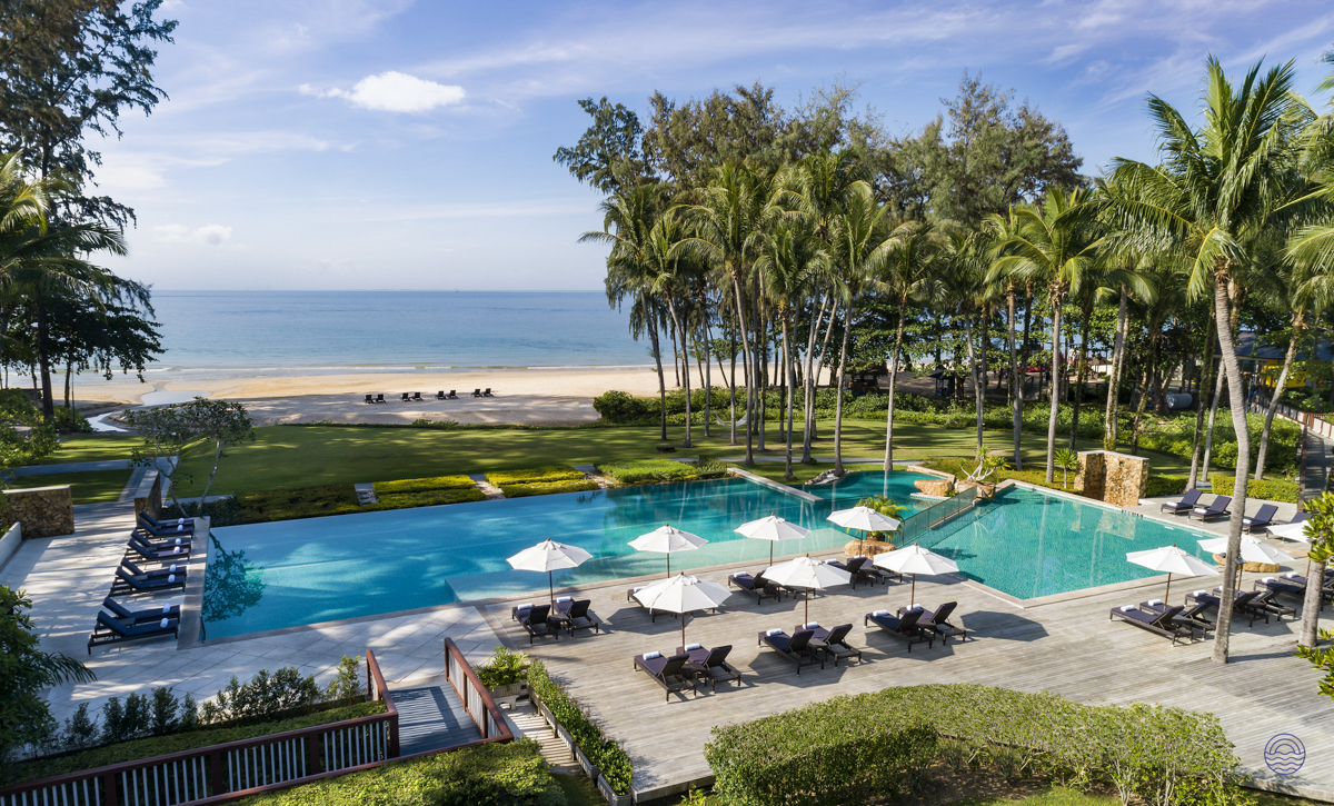 Relax by the luxurious resort pool overlooking the beautiful sandy beach and ocean in Krabi.