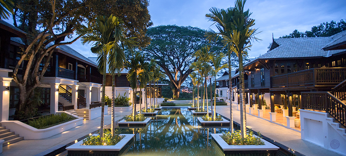 A stunning historical resort in Chiang Mai with serene water features and elegant traditional architecture at dusk.