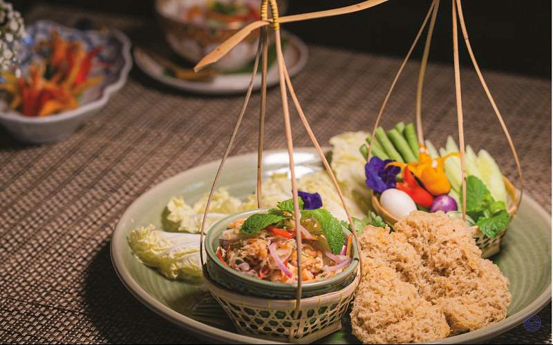 An authentic Thai welcome dinner featuring crispy fish salad, fresh vegetables, and elegant presentation in Bangkok.