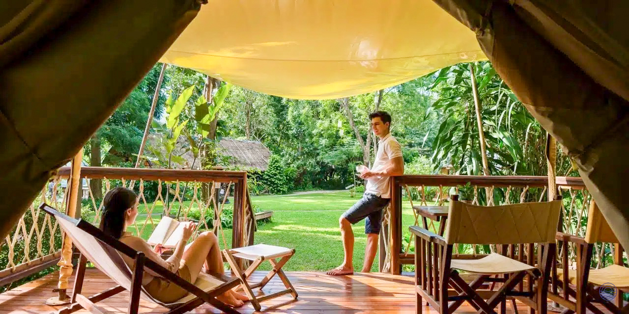 A couple enjoys a peaceful afternoon, reading and relaxing on their resort deck in Chiang Mai.