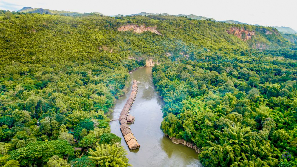 Serene floating bungalows line the River Kwai, nestled within the vibrant green jungle of Kanchanaburi.