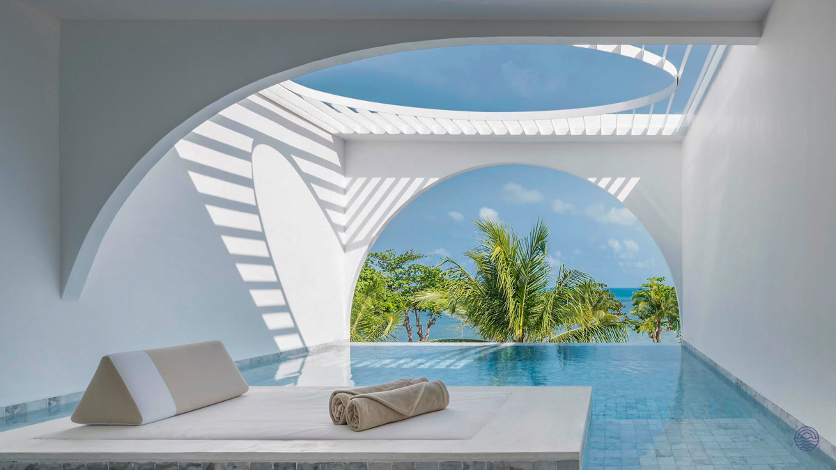 Serene white architecture frames a private pool and ocean view from a luxurious villa in Koh Samui.