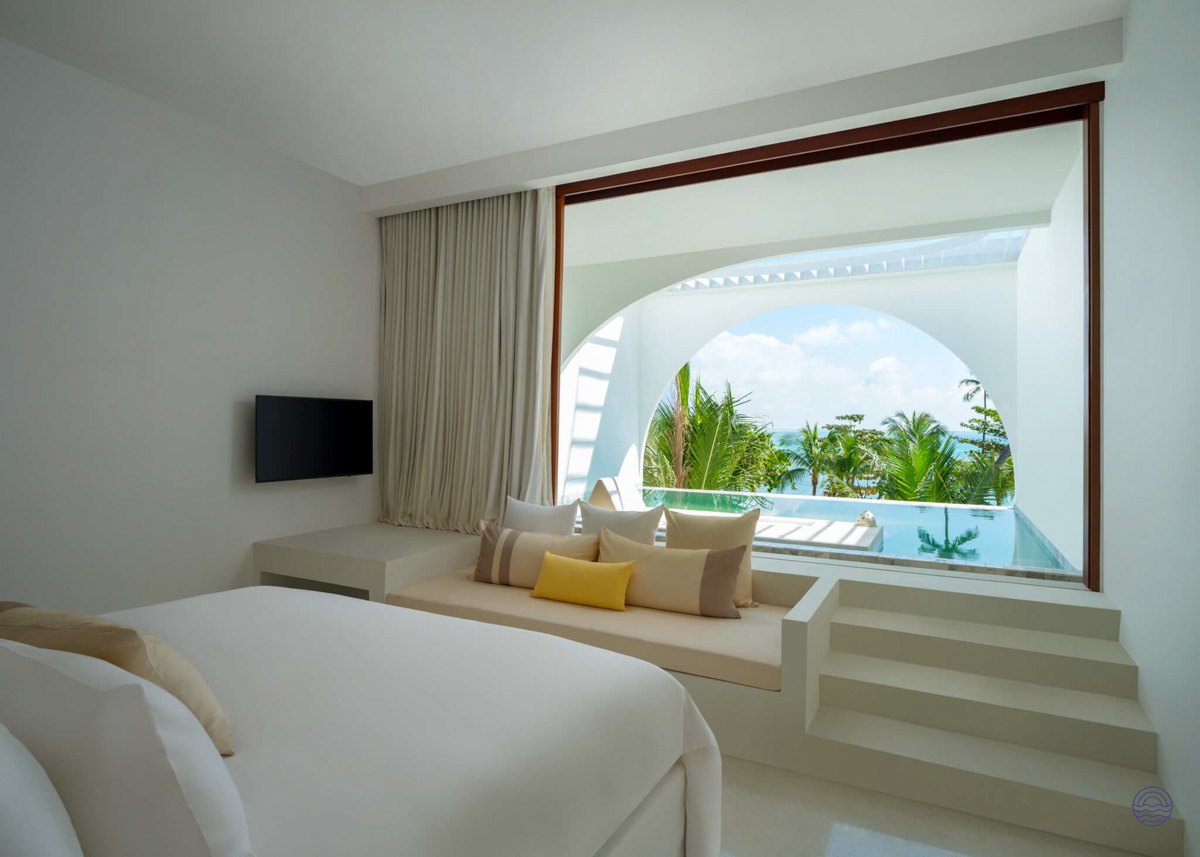 A bright, luxurious hotel room in Koh Samui with a bed and private pool overlooking palm trees.