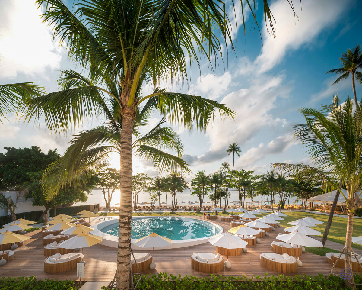 Luxurious beachfront resort in Koh Samui with a stunning circular pool and many sun loungers.