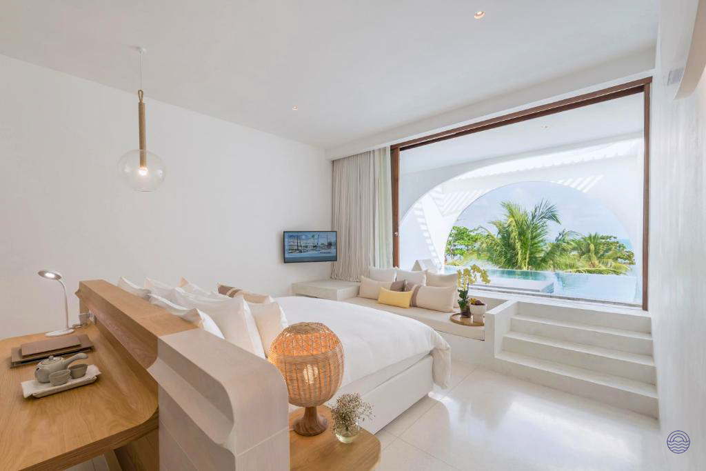 A serene, all-white hotel room in Koh Samui with a private pool and palm tree views.