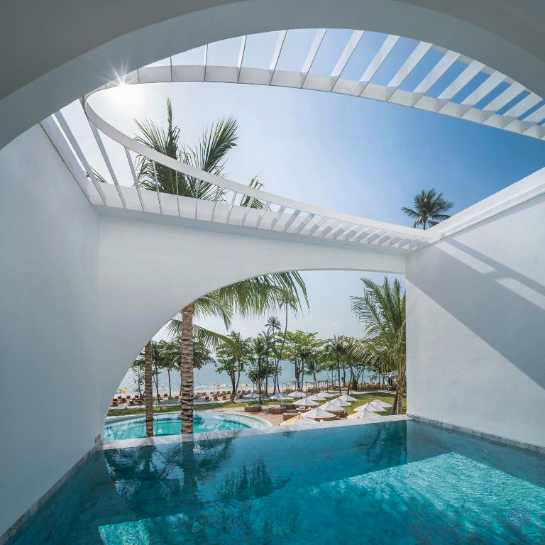 Luxurious infinity pool with a view of the tropical beach and ocean on sunny Koh Samui.