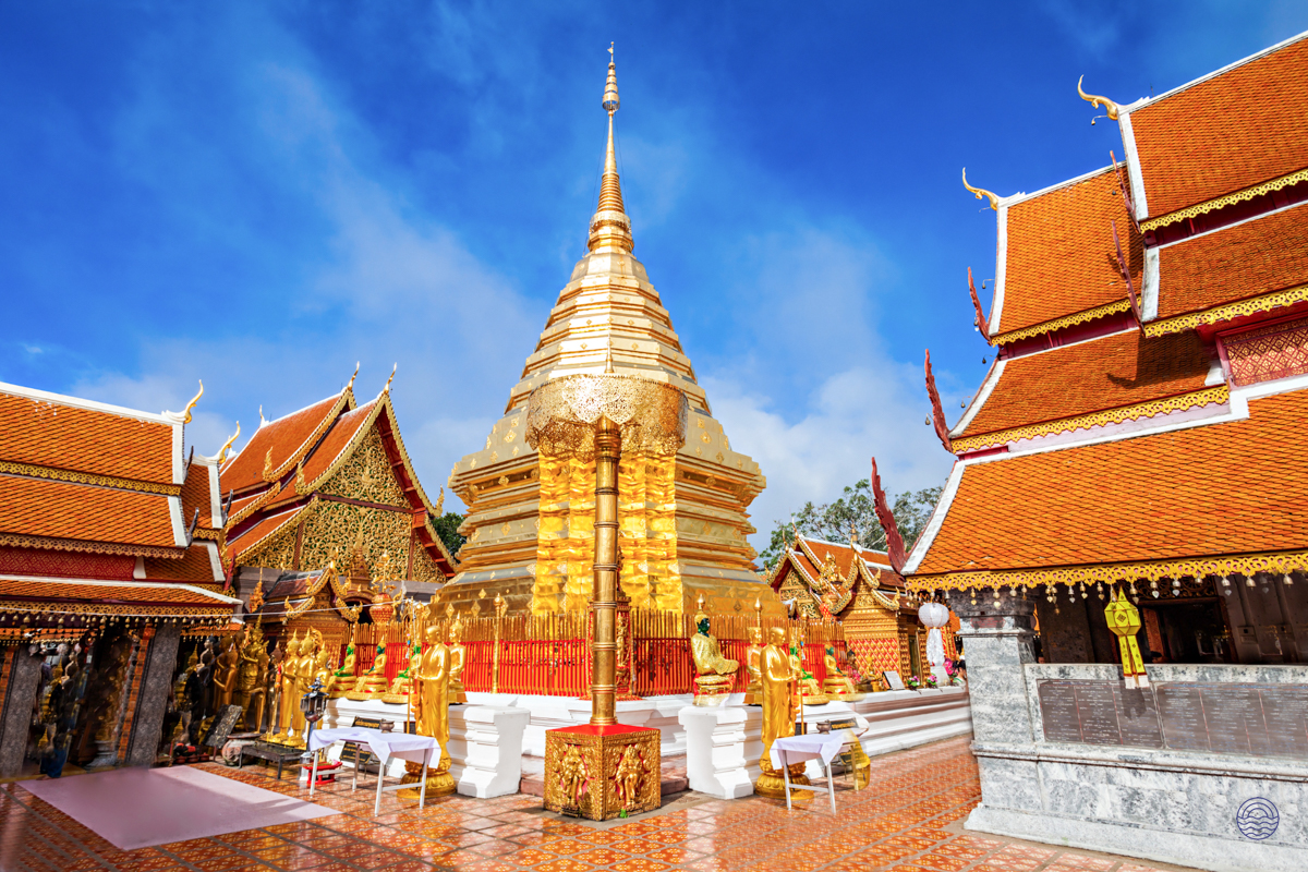 The magnificent golden chedi of Doi Suthep Temple shines brightly under a blue sky in Chiang Mai.