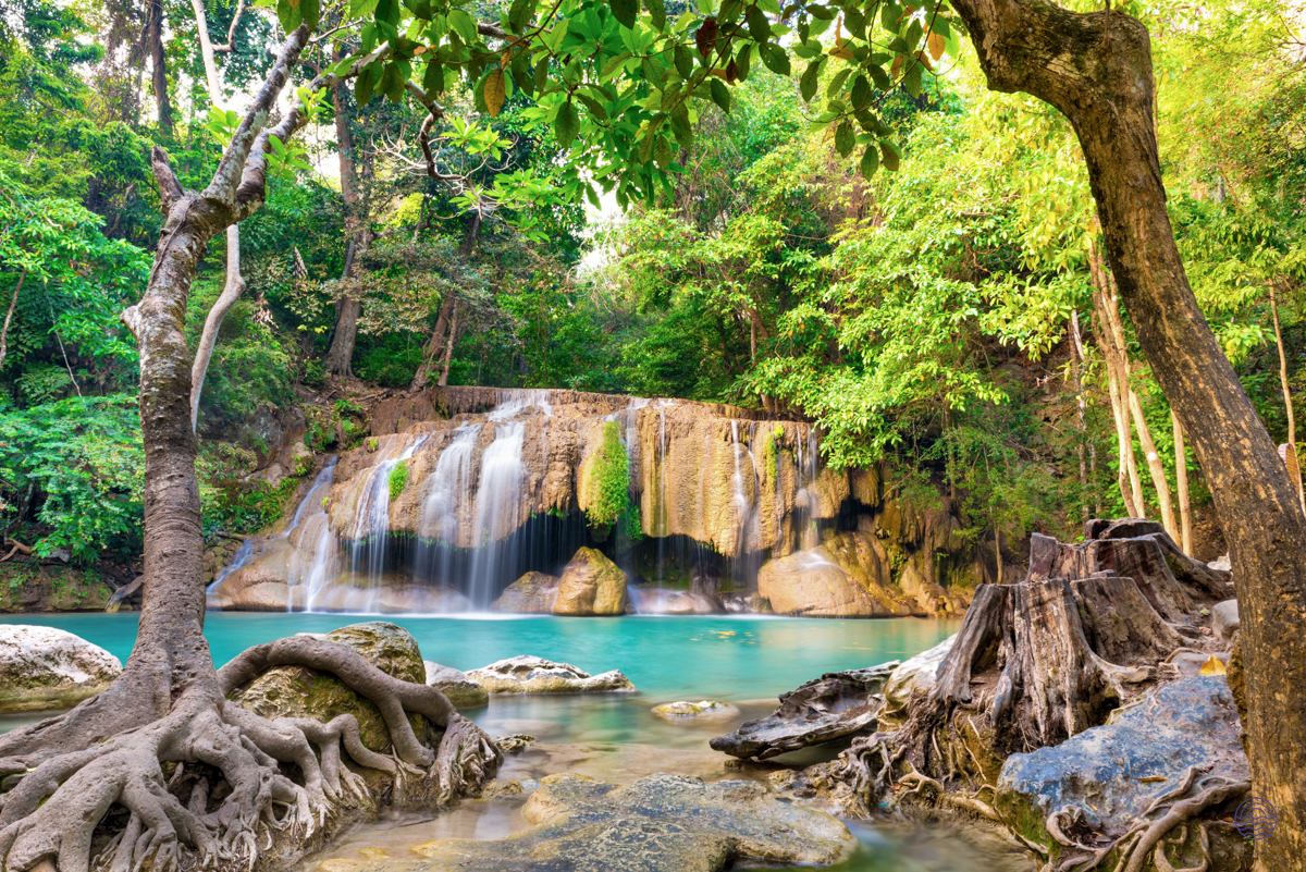 Erawan Waterfalls in Kanchanaburi, Thailand, with clear turquoise pools and lush green forest.