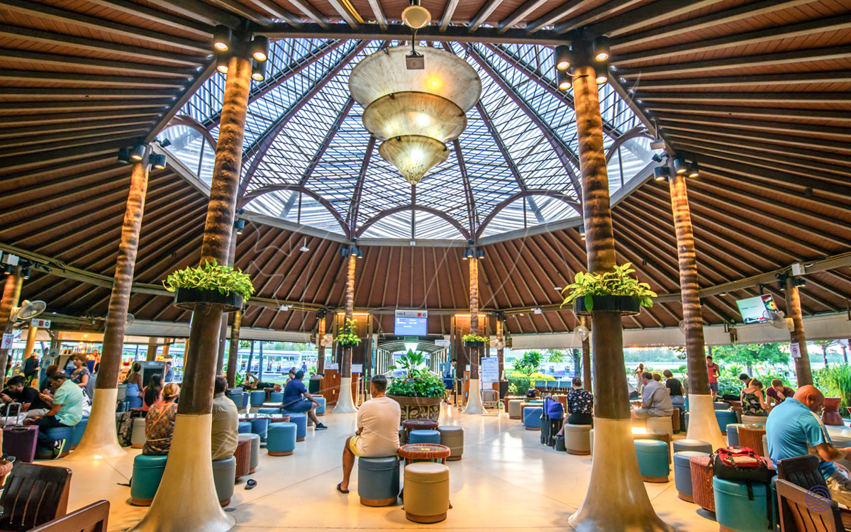 Relaxed travelers enjoy the unique open-air architecture of Koh Samui Airport's spacious terminal building.