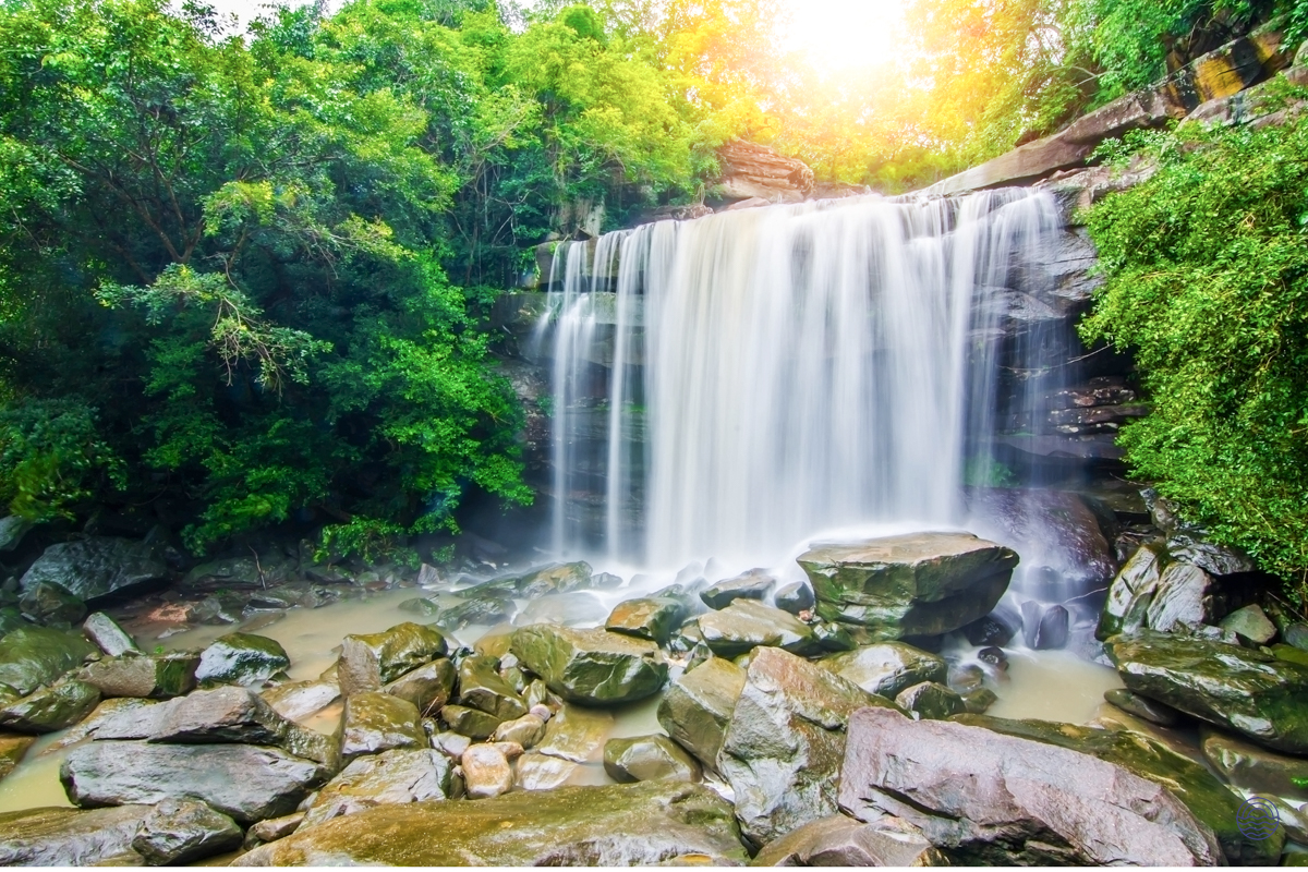 Namuang Waterfall in Koh Samui, Thailand, with water flowing over rocks and vibrant green foliage.