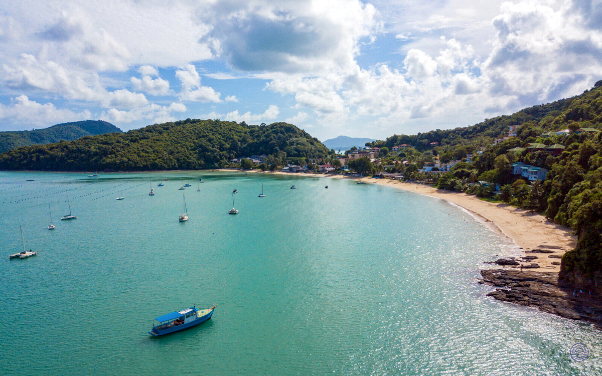 Aerial view of Ao Yon Beach in Phuket, with turquoise waters, sandy shores, and lush green hills.