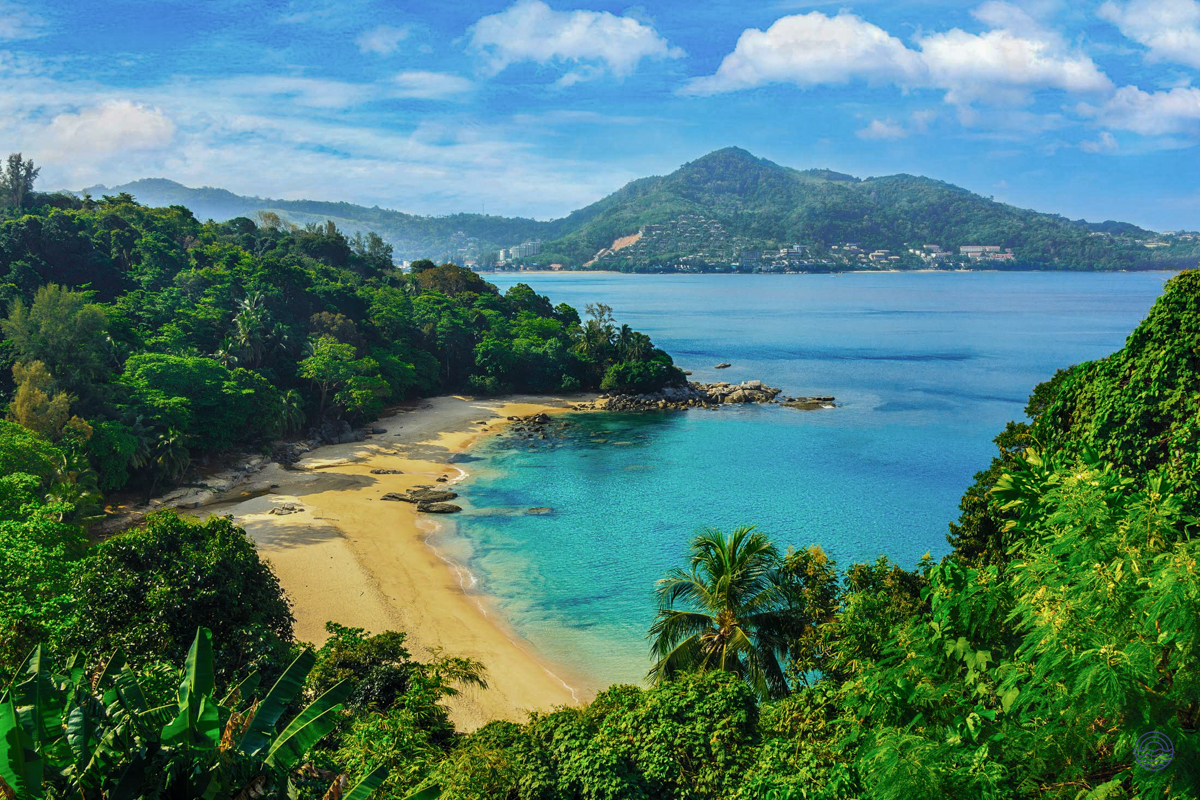 Secluded tropical beach with turquoise water, golden sand, and lush green hills in Phuket, Thailand.