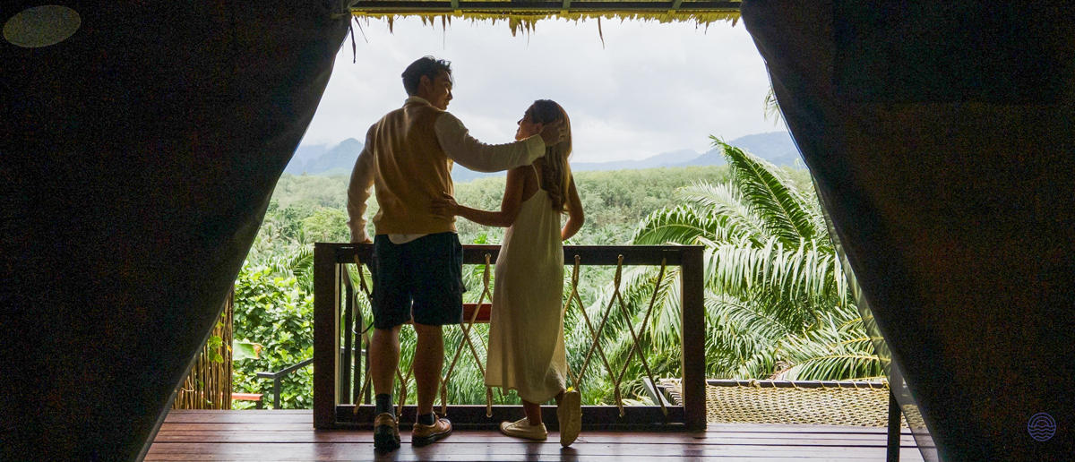 Couple embracing on a balcony, enjoying the tranquil jungle and mountain views in Khao Sok.