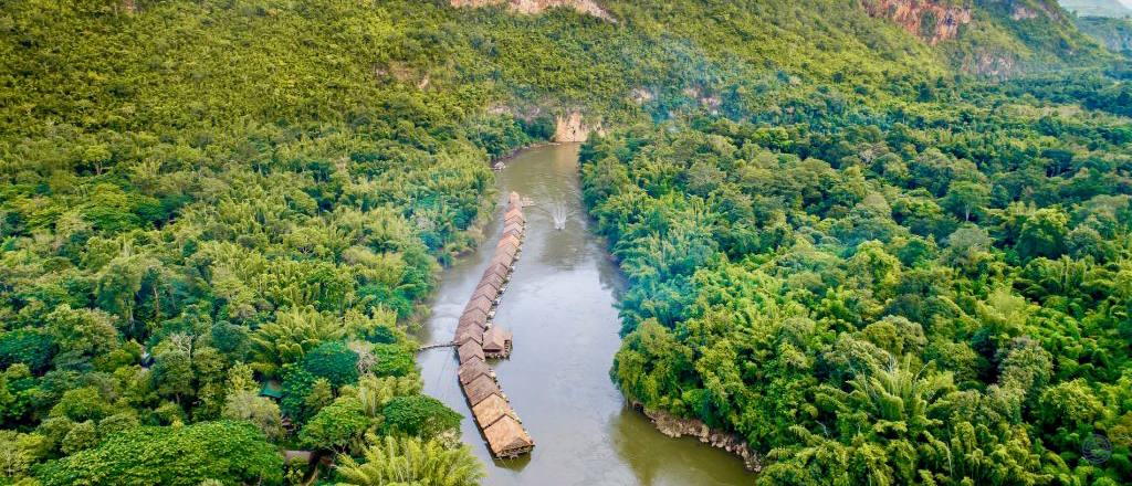 Charming floating bungalows on the River Kwai in Kanchanaburi, nestled within dense green jungle.