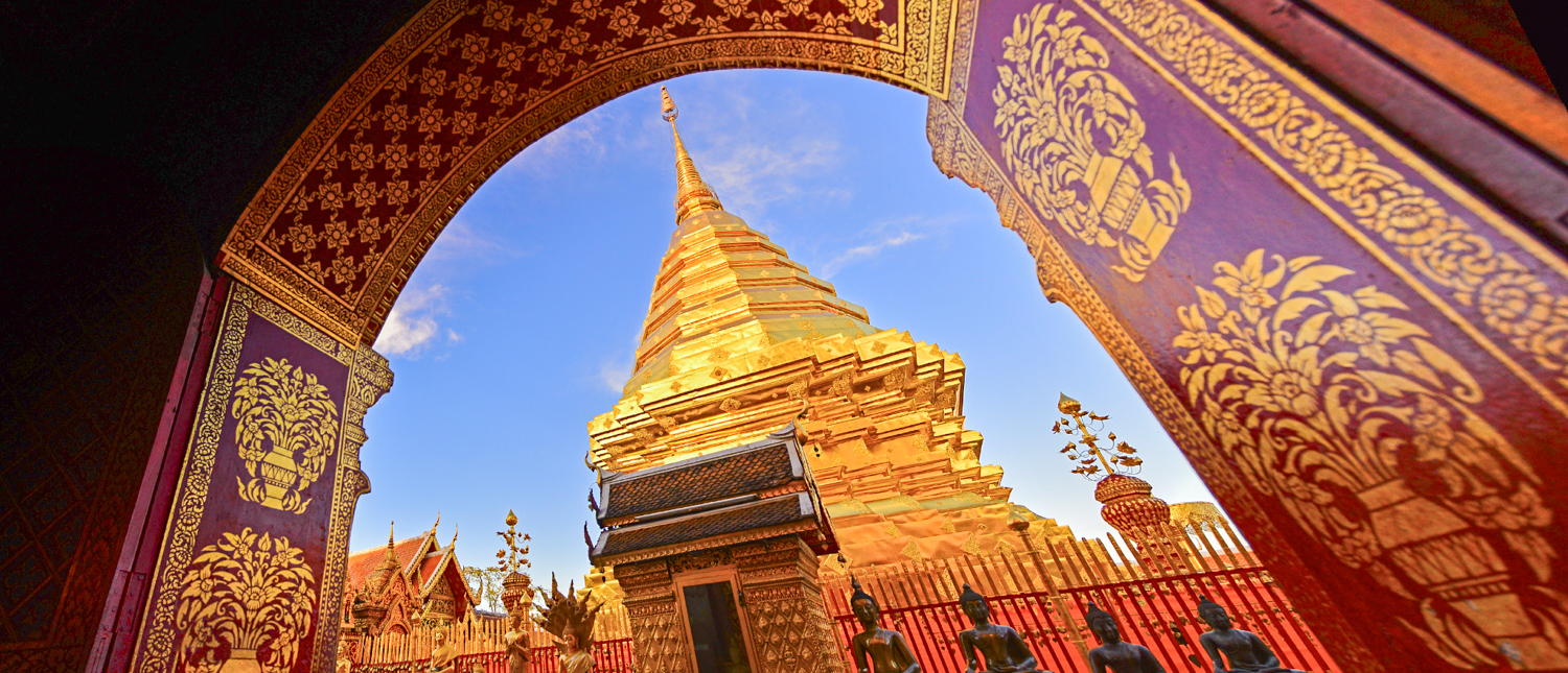 A majestic golden chedi at Doi Suthep Temple in Chiang Mai, framed by an ornate archway.