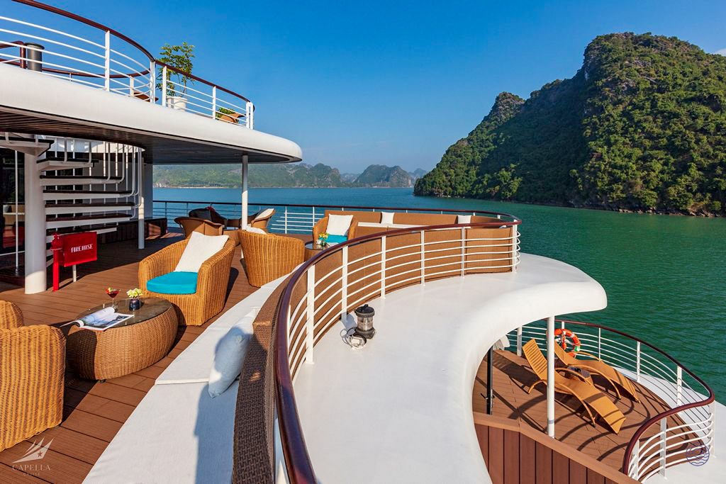 Spacious cruise deck with comfortable lounge chairs offering breathtaking views of Halong Bay.