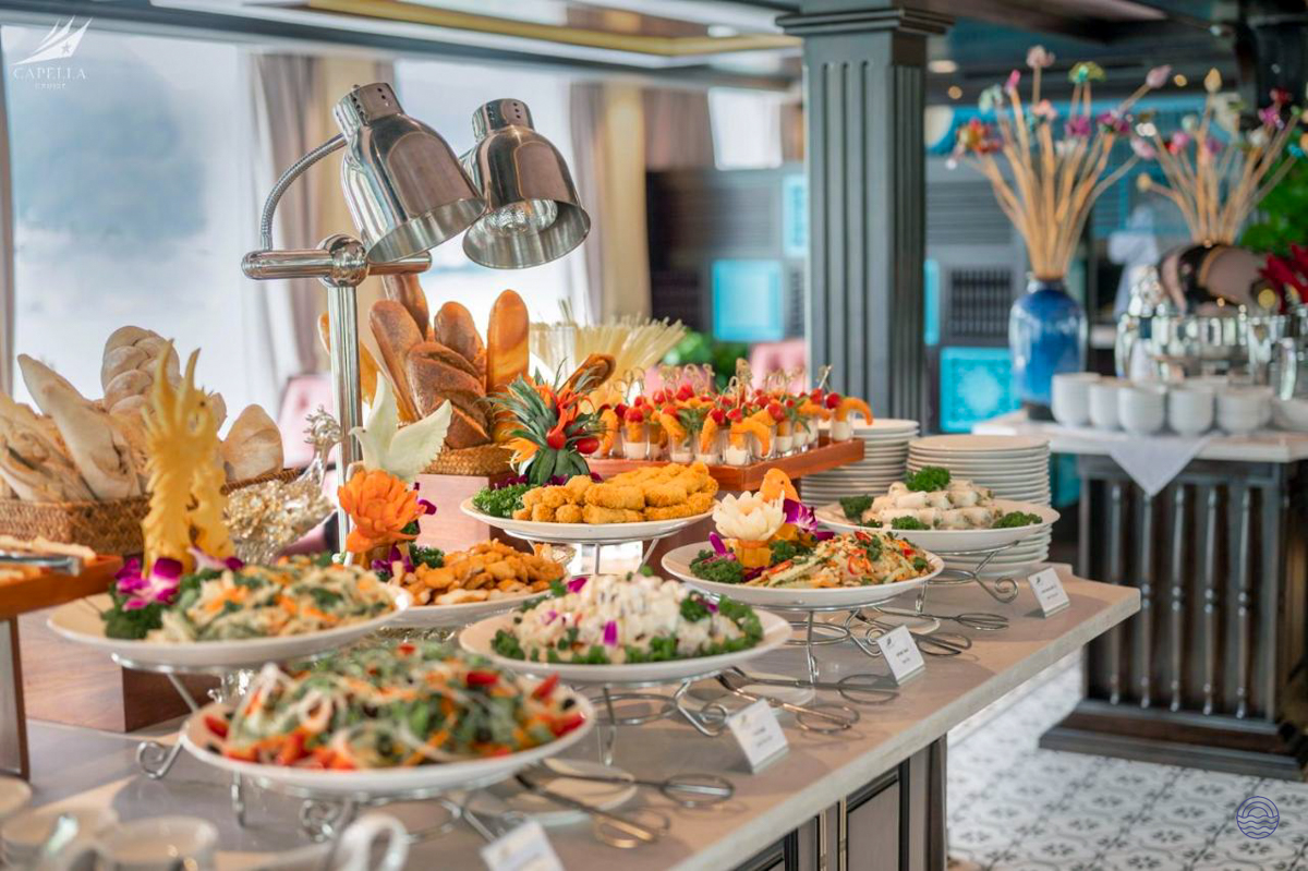 Delicious buffet with diverse dishes, fresh bread, and elegant decor on a Halong Bay cruise.