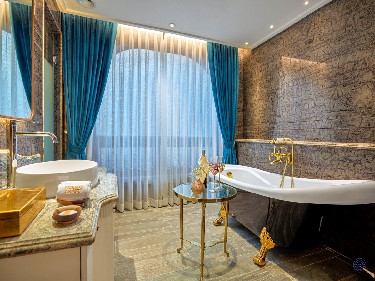 Elegant bathroom at Peridot Grand Luxury Boutique Hotel in Hanoi, featuring a freestanding tub and romantic ambiance.