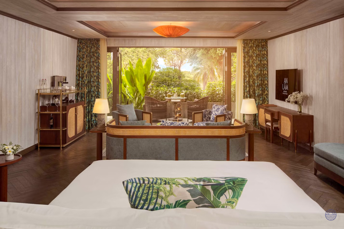 Inviting hotel suite with a large bed, cozy living area, and a tropical garden view in Vietnam.