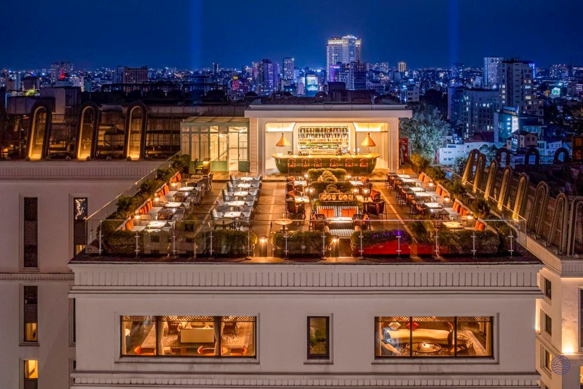 An elegant rooftop bar and restaurant at Mai House Saigon, overlooking the vibrant Ho Chi Minh City skyline.