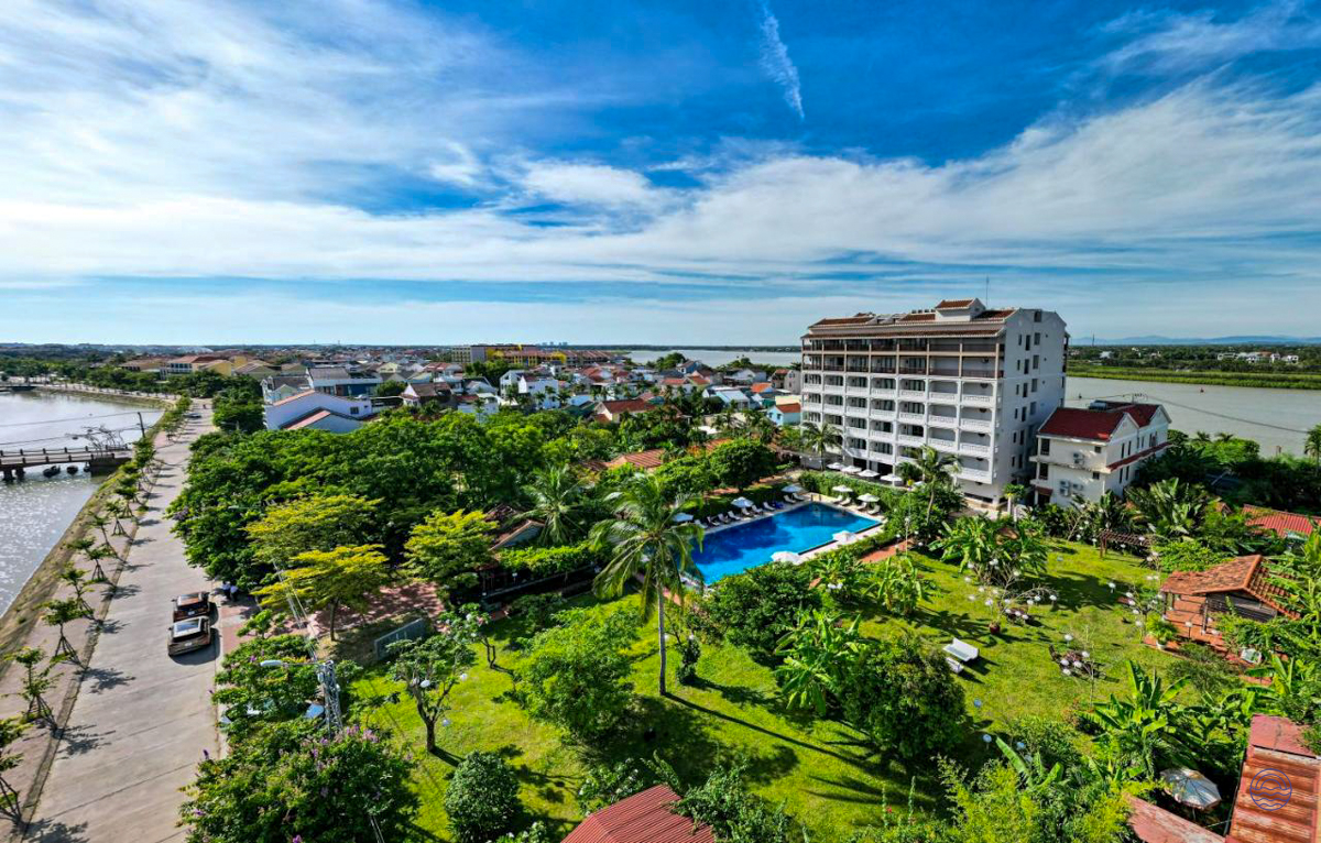 Beautiful hotel in Hoi An with a sparkling pool, lush gardens, and river views.