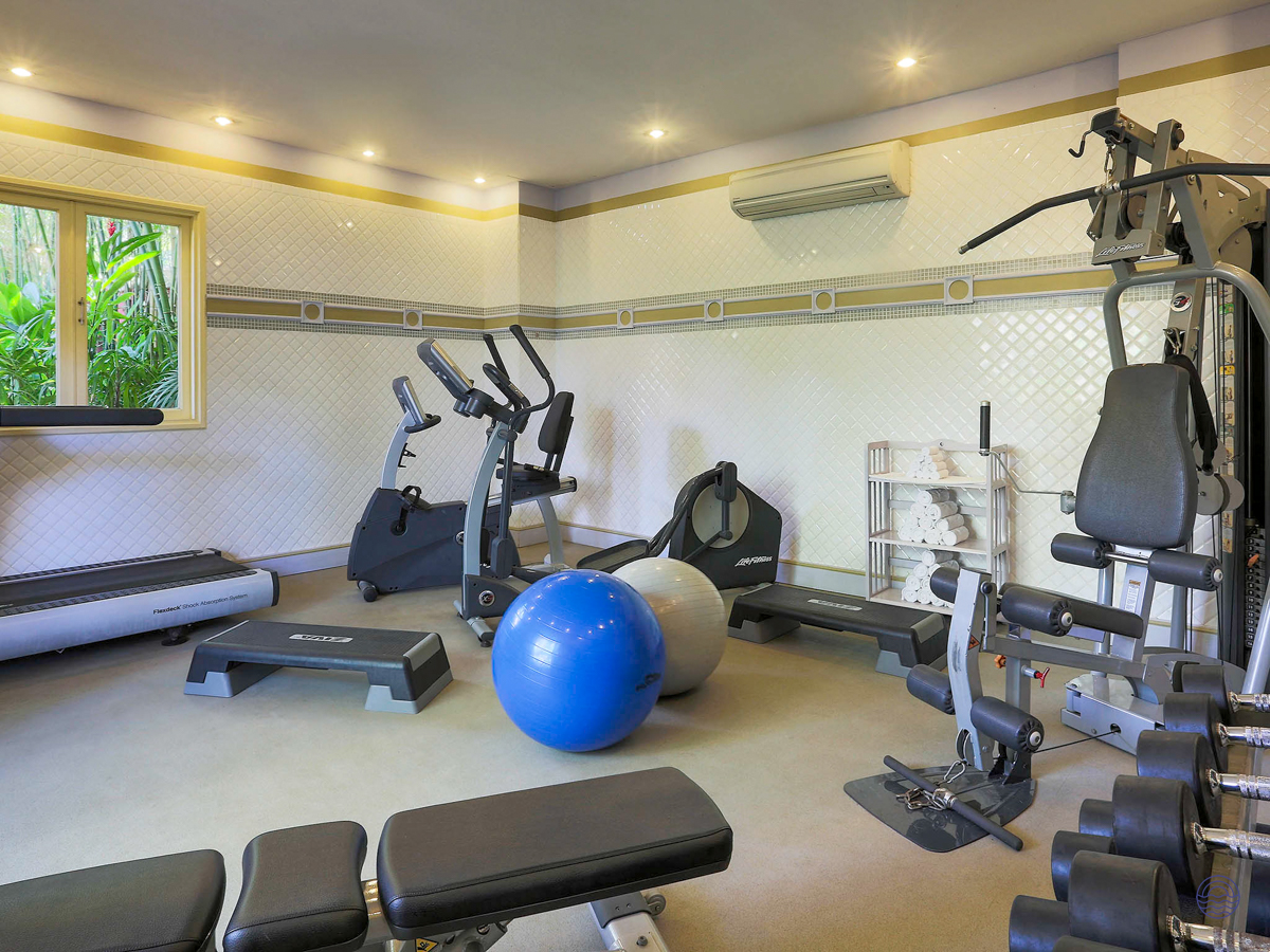 A bright and well-equipped hotel gym with various exercise machines and weights in Phu Quoc.