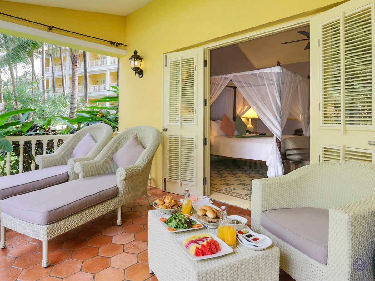 Luxurious resort balcony in Phu Quoc with a delicious breakfast spread and comfortable lounge chairs.