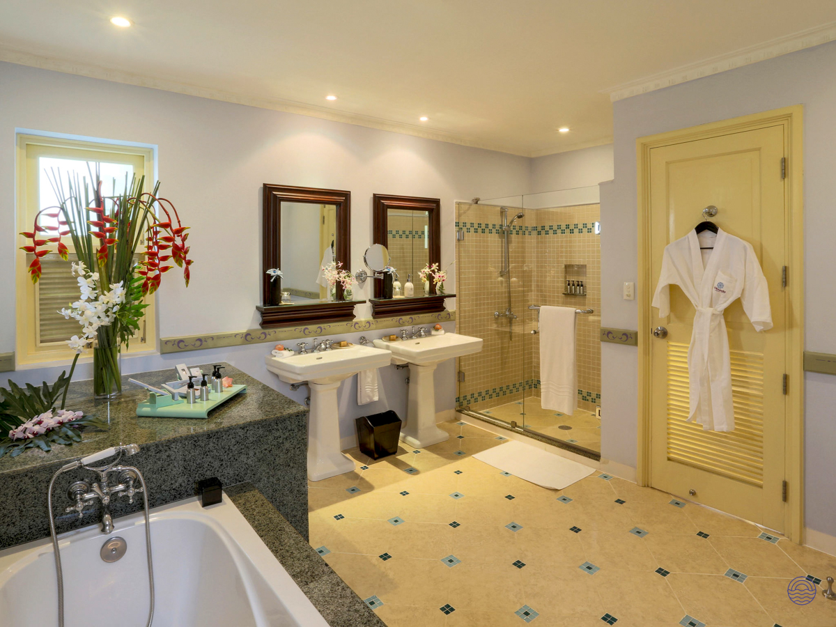 Spacious and elegant hotel bathroom in Phu Quoc with a deep tub, double sinks, and shower.