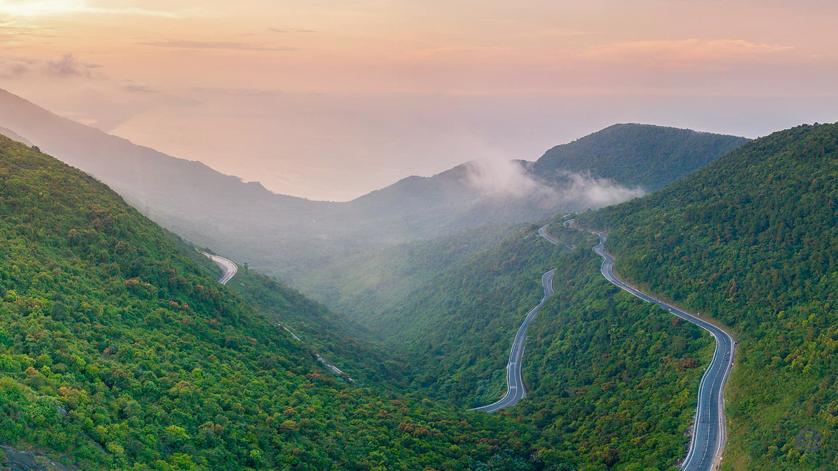 Experience the majestic Hai Van Pass, with winding roads through lush green mountains and misty skies.