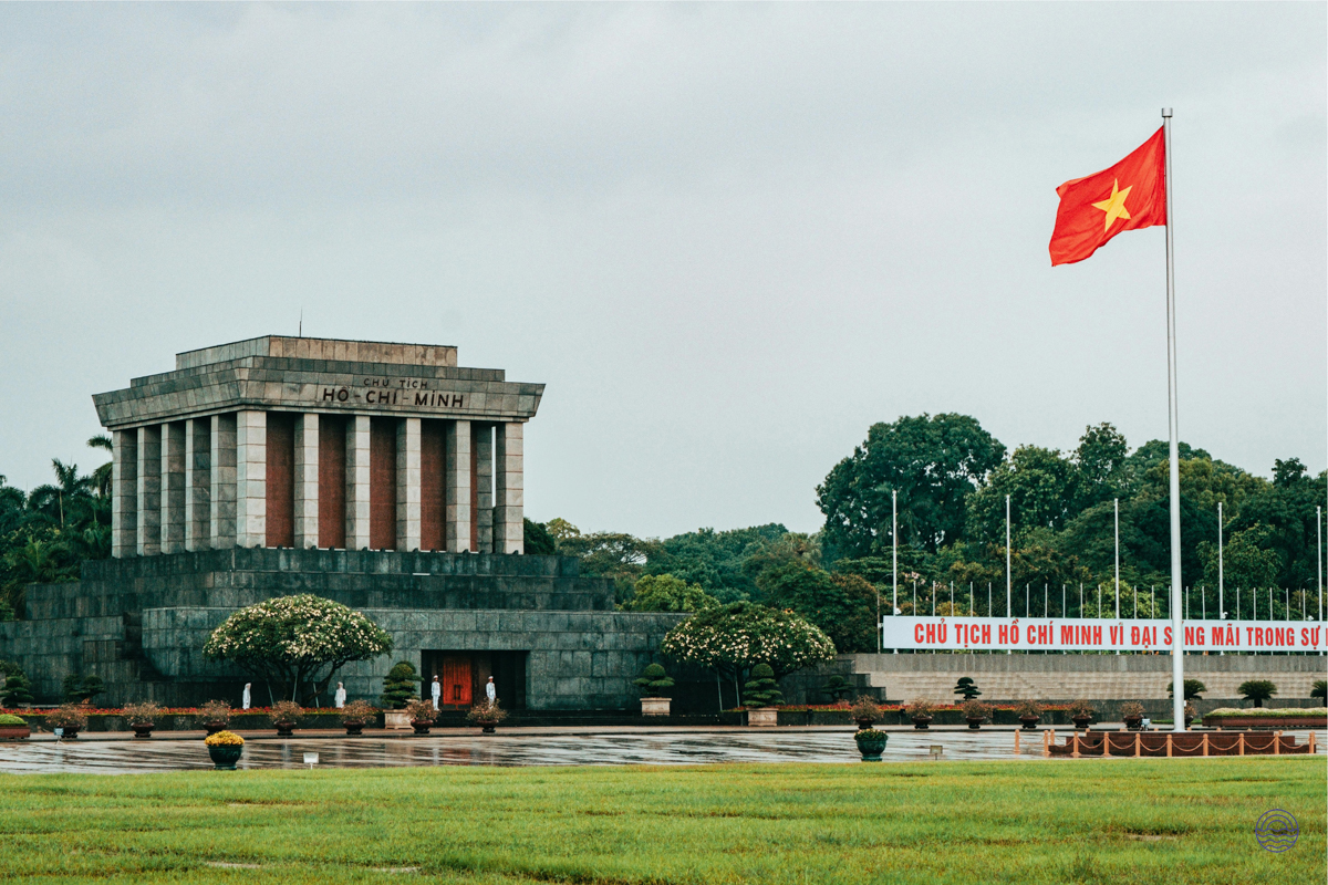 The Ho Chi Minh Mausoleum in Hanoi, a grand and solemn landmark, with the national flag flying.
