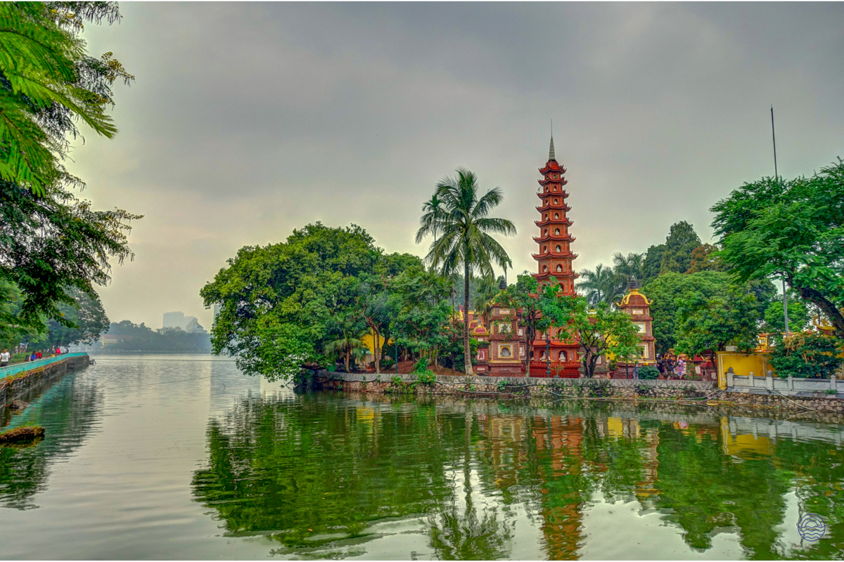 The historic Tran Quoc Pagoda stands majestically on West Lake in Hanoi, surrounded by lush trees.