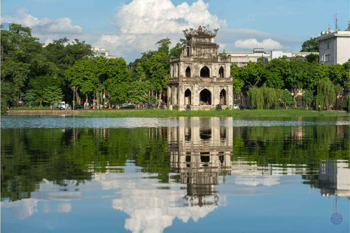 Hanoi's historic Turtle Tower stands majestically, its reflection shimmering on the calm Hoan Kiem Lake.