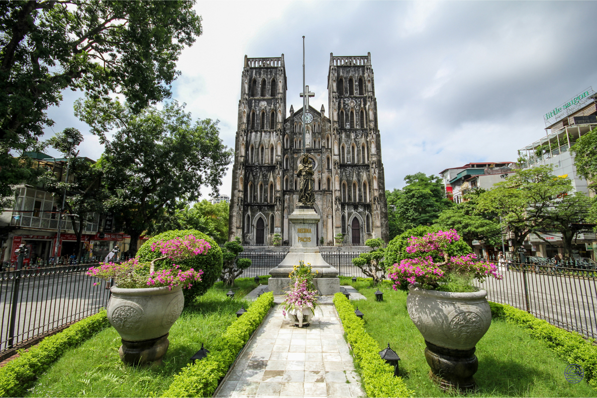 The majestic St. Joseph Cathedral in Hanoi, a neo-Gothic landmark, surrounded by a beautiful green garden.