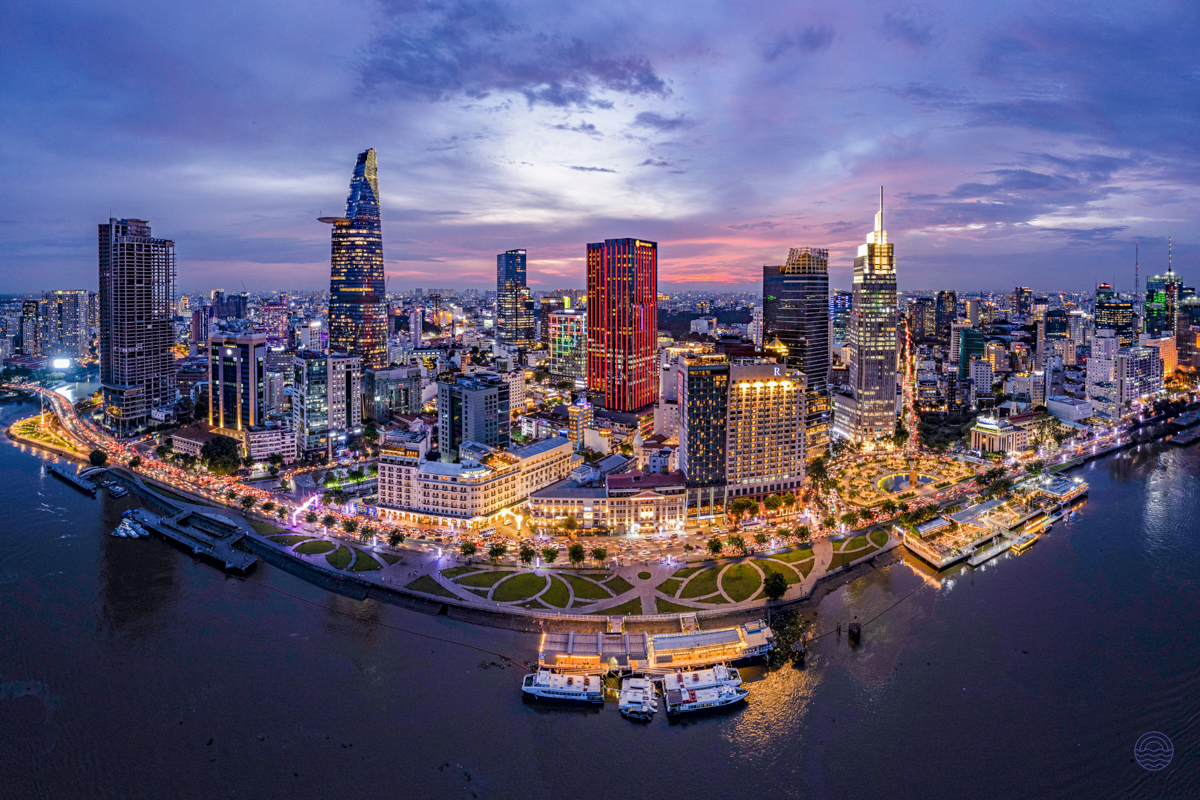 Vibrant Ho Chi Minh City skyline at twilight, with modern buildings glowing along the Saigon River.